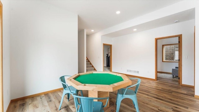 rec room with light wood-style flooring, visible vents, and baseboards