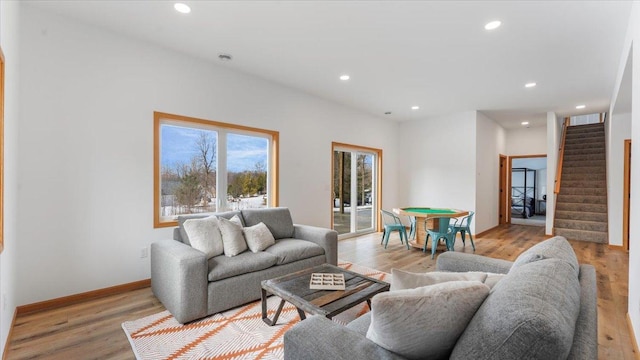 living area featuring light wood-type flooring, baseboards, recessed lighting, and stairs