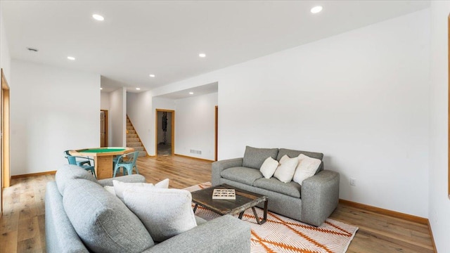 living room with light wood finished floors, stairway, and recessed lighting