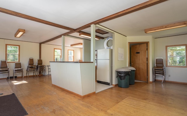 kitchen featuring light wood-style floors, freestanding refrigerator, a healthy amount of sunlight, and beamed ceiling