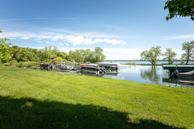 view of dock with a water view and a yard