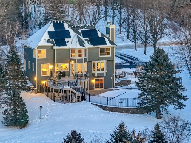 snow covered property featuring stairway, fence, and a chimney