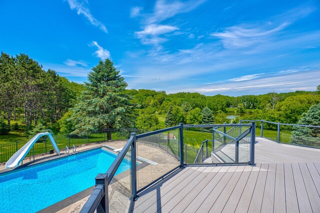 880 Norell Ave N, West Lakeland Twp, MN 55082 - view of swimming pool featuring a water slide, a wooden deck, and a forest view