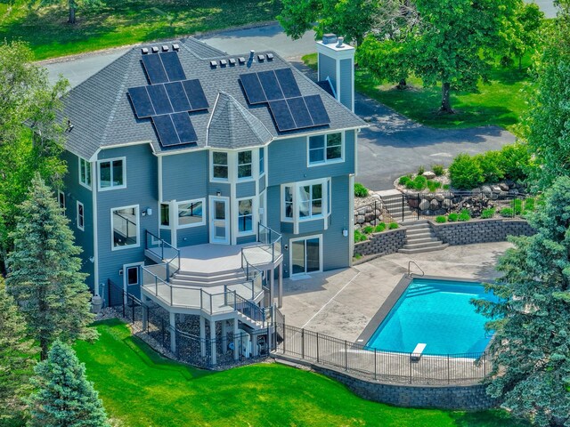 880 Norell Ave N, West Lakeland Twp, MN 55082 - rear view of house with stairway, roof mounted solar panels, a chimney, roof with shingles, and a patio area