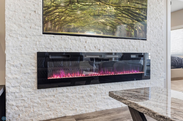 room details with a glass covered fireplace and wood finished floors