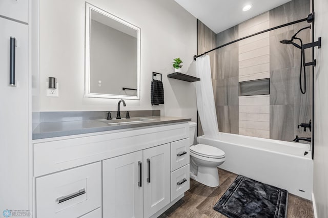 full bath featuring toilet, wood finished floors, vanity, and shower / tub combo with curtain