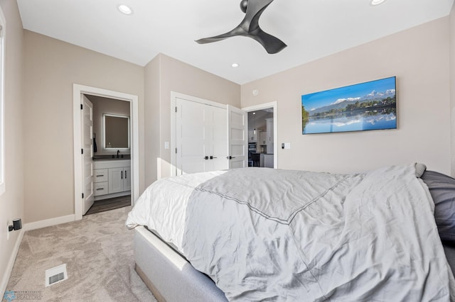 bedroom featuring recessed lighting, light colored carpet, visible vents, ensuite bathroom, and baseboards