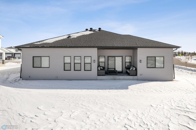 snow covered house with roof with shingles