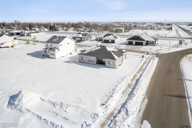 snowy aerial view with a residential view