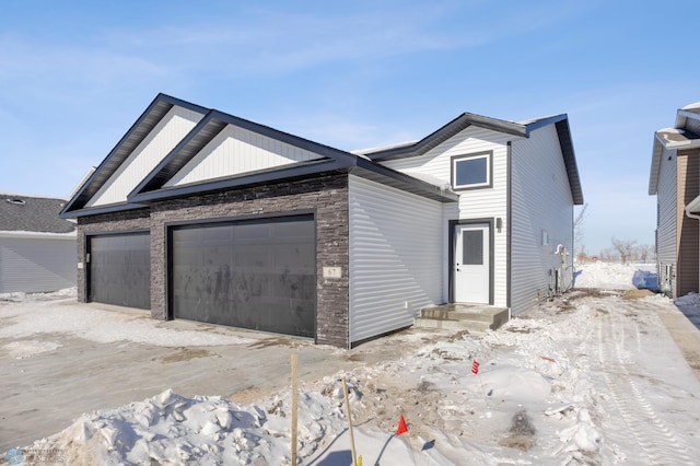 view of front of property with a garage and stone siding