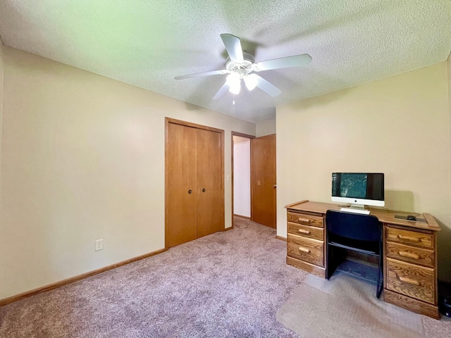 unfurnished office with ceiling fan, light colored carpet, and a textured ceiling