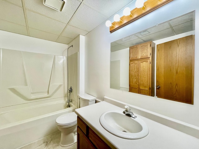 full bathroom featuring  shower combination, toilet, vanity, and a drop ceiling