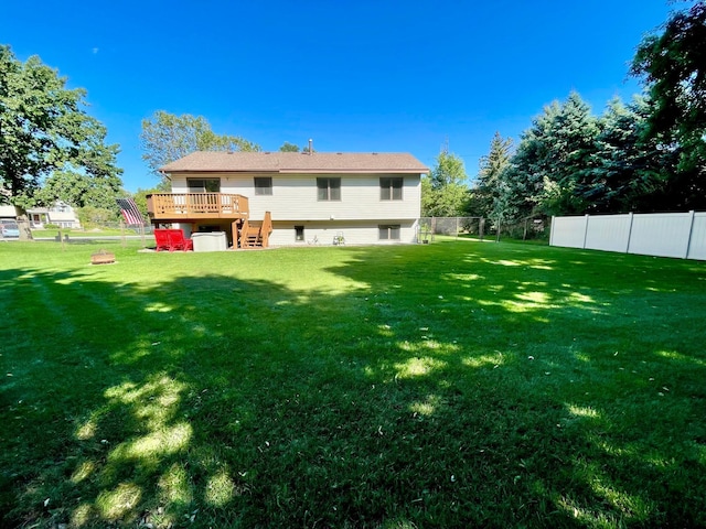 back of property with a wooden deck and a yard