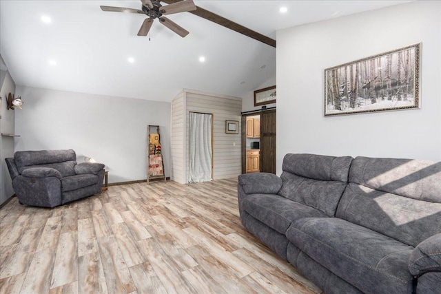 living room featuring light hardwood / wood-style flooring, ceiling fan, a barn door, high vaulted ceiling, and beam ceiling