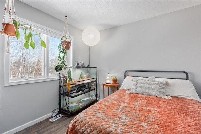 bedroom with a textured ceiling and dark wood-type flooring