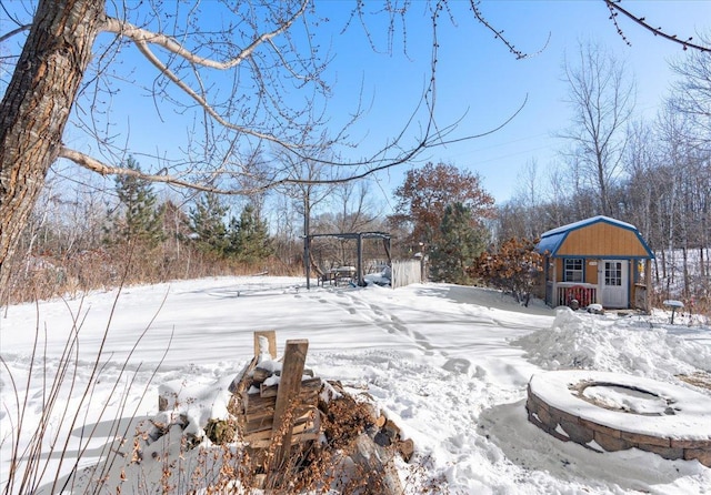 snowy yard featuring an outdoor structure