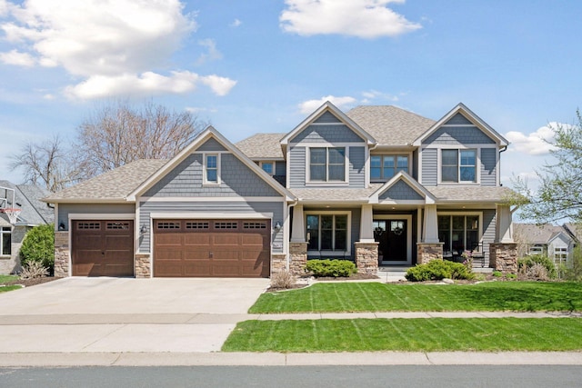 craftsman house featuring covered porch, driveway, a front yard, a garage, and stone siding