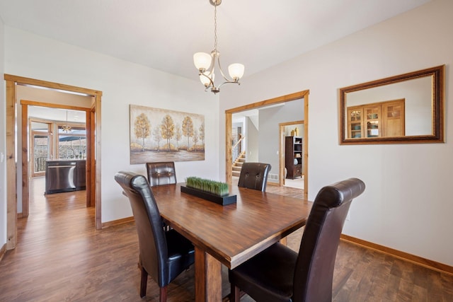 dining room with an inviting chandelier, baseboards, and wood finished floors