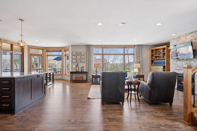 living area featuring recessed lighting, dark wood finished floors, and a fireplace
