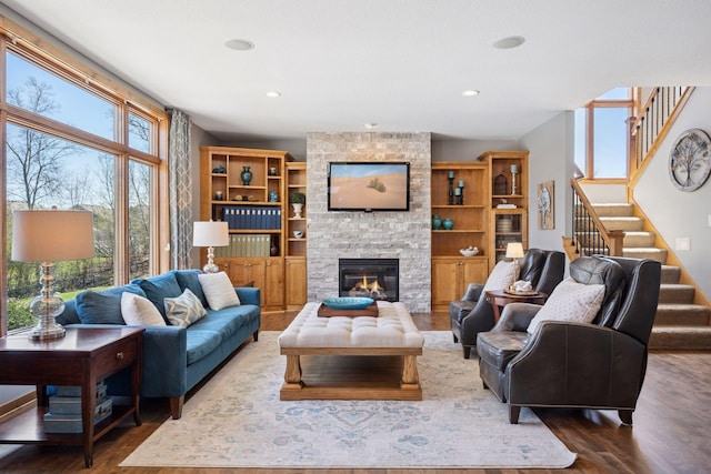 living area featuring stairs, dark wood-style flooring, recessed lighting, and a fireplace