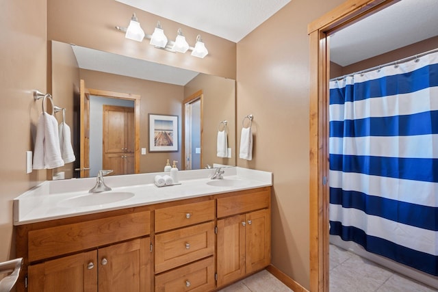 full bath with double vanity, a sink, a shower with shower curtain, and tile patterned floors