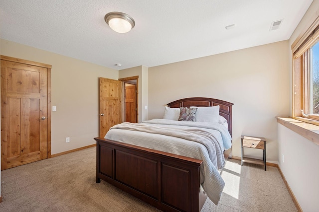 bedroom featuring baseboards, light carpet, and visible vents