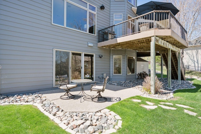 back of house featuring a lawn, stairway, a wooden deck, and a patio area