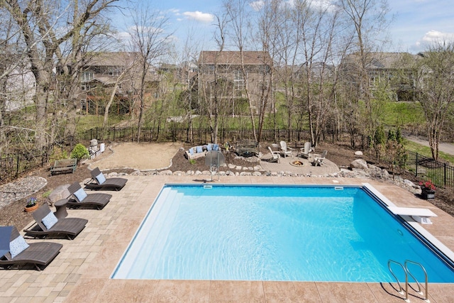 view of swimming pool with fence, a fenced in pool, a patio, and a diving board