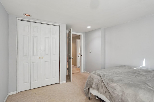 bedroom featuring light carpet and a closet