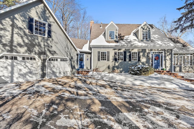 cape cod home with entry steps, driveway, and a chimney