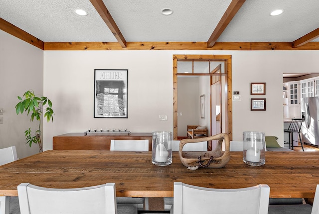 dining area featuring a textured ceiling, beamed ceiling, and recessed lighting