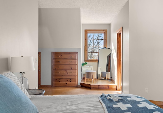 bedroom with a textured ceiling and light wood-style floors