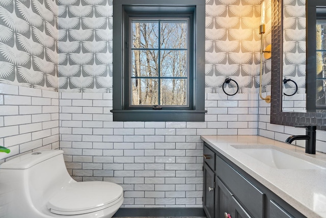 half bathroom featuring vanity, toilet, and tile walls