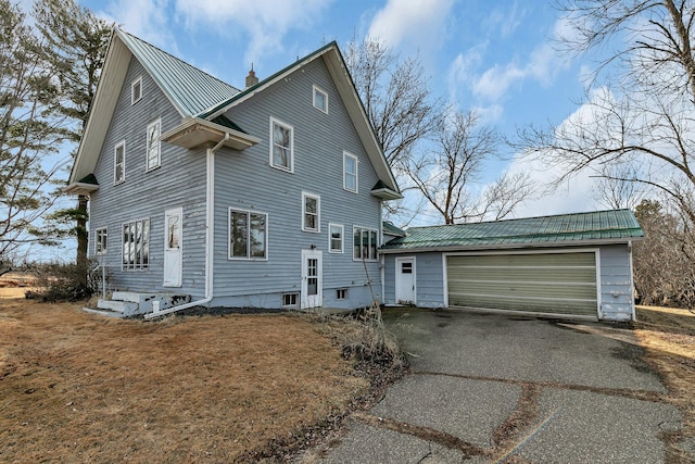 view of front of home featuring a chimney, metal roof, and a garage