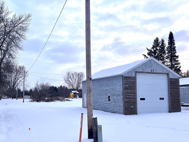 snow covered garage featuring a garage