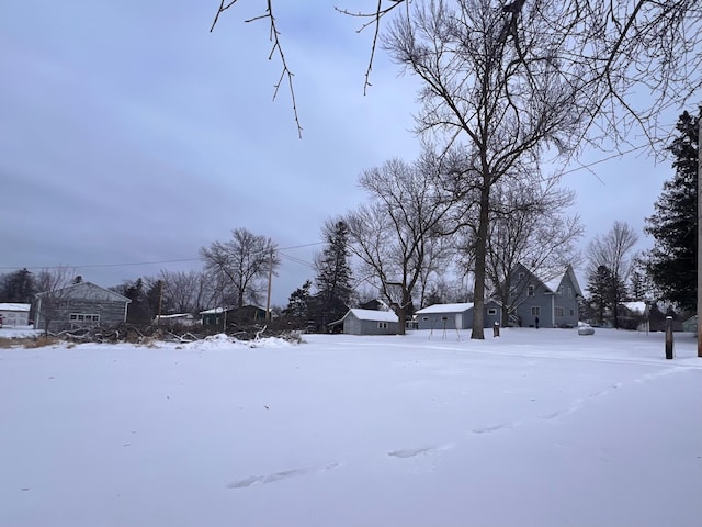 yard covered in snow with an outdoor structure and a storage unit