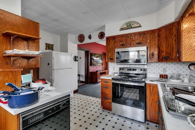 kitchen featuring light countertops, open shelves, light floors, and appliances with stainless steel finishes