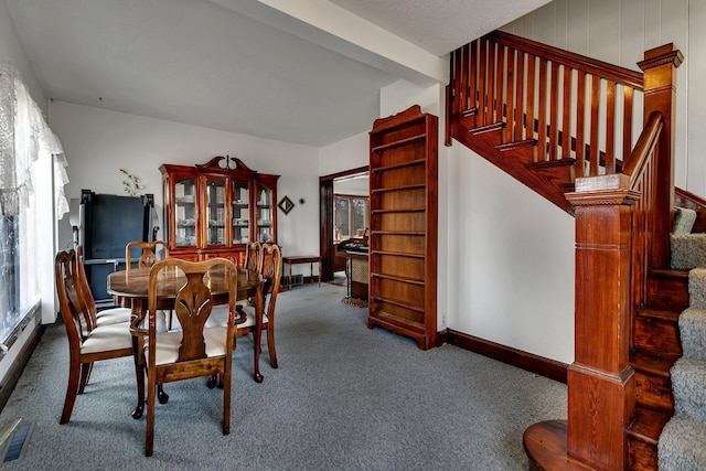 carpeted dining space featuring stairway, visible vents, and baseboards