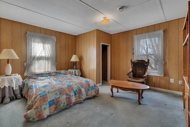 carpeted bedroom with visible vents, baseboards, a textured ceiling, and wood walls