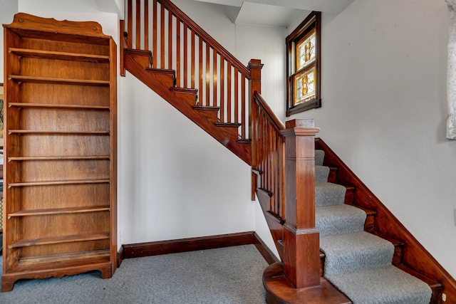 staircase featuring carpet and baseboards