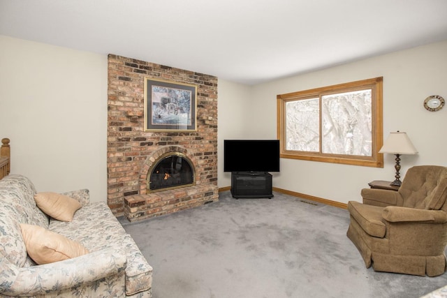 carpeted living area with a brick fireplace and baseboards