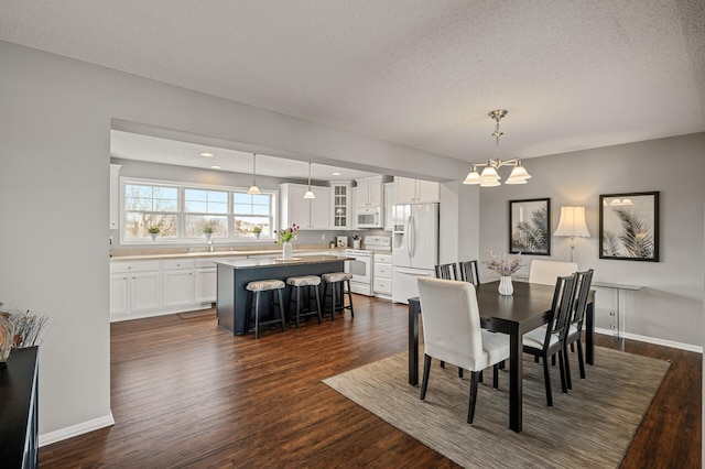 dining room with baseboards, dark wood finished floors, a chandelier, recessed lighting, and a textured ceiling