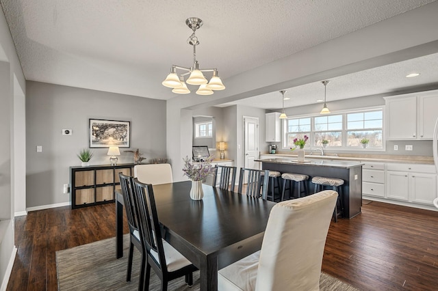 dining space with dark wood-style floors, a healthy amount of sunlight, and a textured ceiling