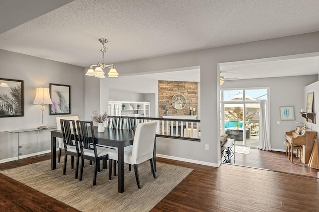 dining room with a notable chandelier, wood finished floors, baseboards, and a textured ceiling