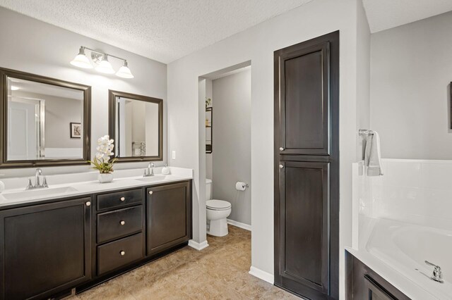 full bathroom featuring a textured ceiling, toilet, a bath, and a sink