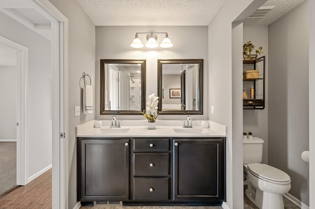 full bath featuring a sink, visible vents, and a textured ceiling