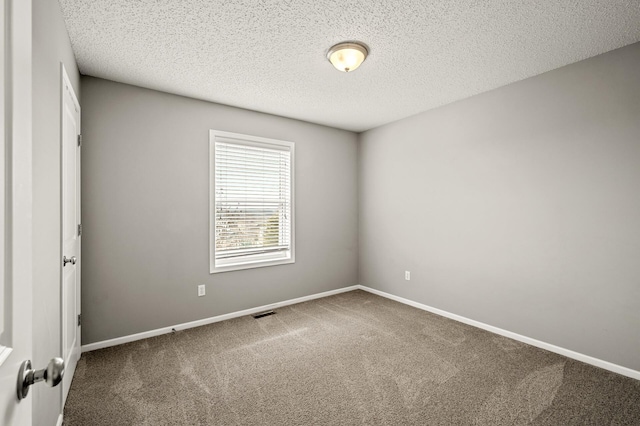 carpeted empty room featuring visible vents, baseboards, and a textured ceiling