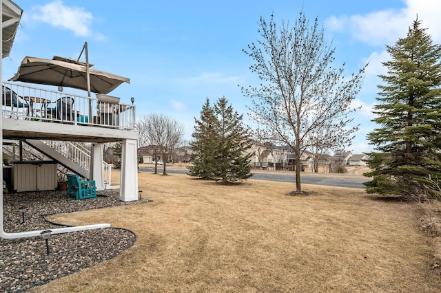 view of yard with stairs and a deck