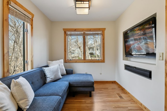 living area featuring baseboards, visible vents, and light wood-style floors