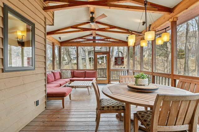 sunroom / solarium featuring a deck, hardwood / wood-style floors, an outdoor living space, a ceiling fan, and vaulted ceiling with beams